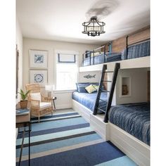 a bedroom with two bunk beds and a blue striped rug on the floor in front of it