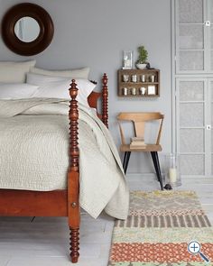 a bed room with a neatly made bed and a rug on the floor next to it