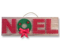 a wooden sign that says noel with a green wreath and red bow hanging from it