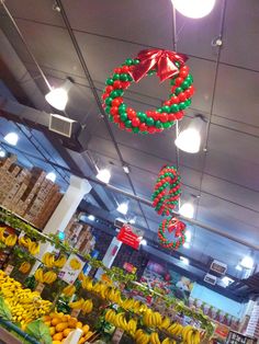 a fruit stand with bananas, oranges and other fruits hanging from it's ceiling