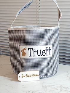 a blue and white gingham basket with a label that says truett on it