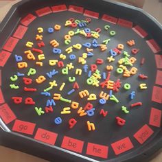 letters and numbers are arranged in the shape of a circle on top of a black tray