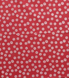 a red and white polka dot fabric with small white flowers on the top of it