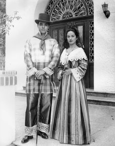 an old black and white photo of a man and woman dressed up in period costumes