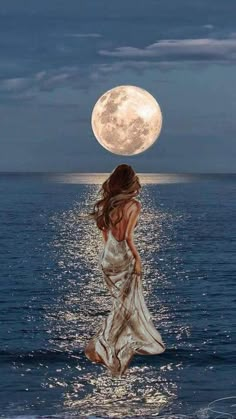 a woman standing in the water with her back to the camera as she looks at the moon