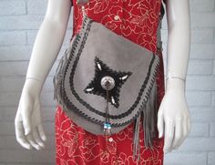 "Awesome 1970s Western style shoulder bag in gray suede. It has a flap closure detailed with black leather & suede and a silver medallion. The bag has gray suede fringe as well as beaded fringe at the medallion. It has a removable shoulder strap and a small handle attached at the top back. It's also top stitched with black leather cord. The interior is unlined suede and includes one small zippered side pocket. No label - there's a label that reads Made in Pakistan. Measurements: the bag is approx 11\" tall and 11.5\" wide. The fringe is 6\" long and the removable strap is 40\" long (can be adjusted smaller). Material: leather and suede, plus a silver tone metal medallion and beads. Condition: very good vintage condition. A small amount of the leather top stitching is missing (it looks like Suede Bags With Silver-tone Hardware For Everyday Use, Chic Suede Shoulder Bag With Silver-tone Hardware, Fringe Satchel Shoulder Bag, Bohemian Brown Shoulder Bag With Fringe, Daily-use Brown Bag With Fringe, Fringe Bags, Suede Fringe, Gray Suede, Vintage Western