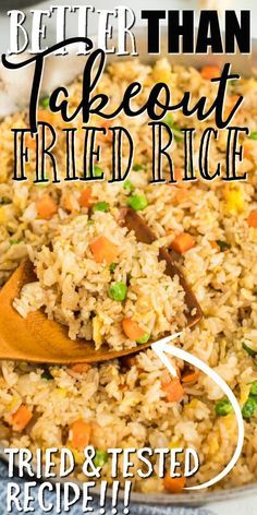 a close up of rice and carrots in a pan with a wooden spoon next to it