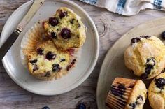 blueberry muffins on plates next to a fork