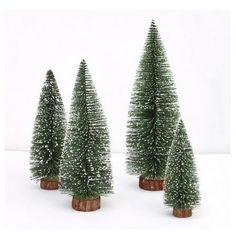 three small christmas trees sitting in front of each other on top of a white surface