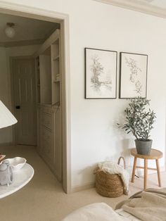 a bedroom with white walls and pictures on the wall