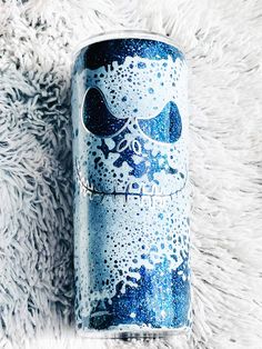 a blue and white can sitting on top of a furry surface with snow flakes