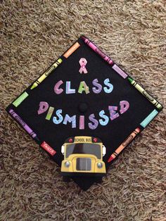 a black graduation cap with the words class pissied on it and a school bus