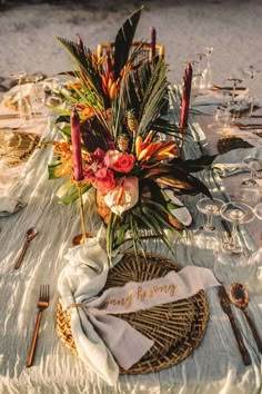 the table is set with an arrangement of flowers, candles and napkins on it