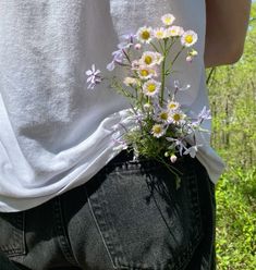 a person with their back to the camera holding flowers in their pocket