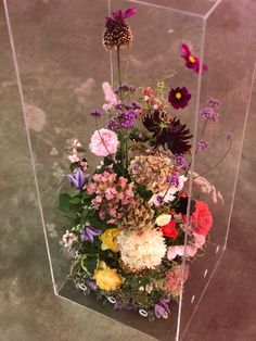 a clear vase filled with lots of colorful flowers