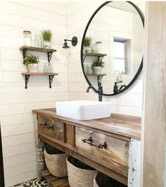 a bathroom sink sitting under a mirror next to two baskets filled with plants and other items