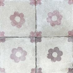 four square tiles with pink and white flowers painted on the tile in different sizes, shapes and colors