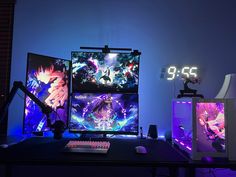 two computer monitors sitting next to each other on top of a desk in front of a clock