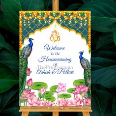 a welcome sign with two peacocks on it in front of green leaves and flowers