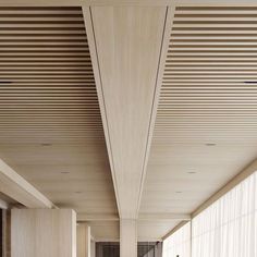 the interior of a modern building with wood slats on the ceiling and flooring