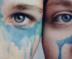 two people with painted faces are looking at the camera