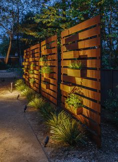 a wooden fence with plants growing on it at night in the park or garden area