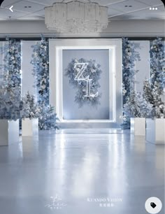 a white room decorated with blue flowers and greenery for an elegant wedding ceremony or special event