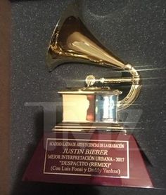 an award is displayed in front of a black and gold wall with a trumpet on it