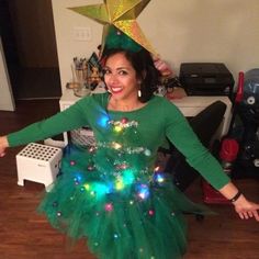 a woman wearing a green dress with lights on it and a star above her head