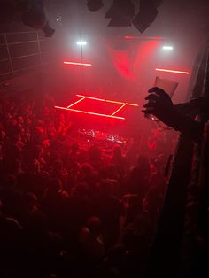 a crowd of people in a dark room with red lights