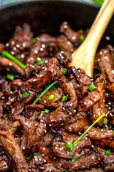 beef with sesame seeds and green onions in a skillet, ready to be eaten