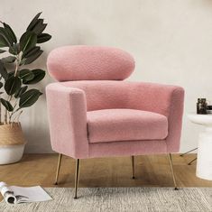 a pink chair sitting next to a potted plant