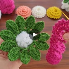 crocheted flowers are being held by someone's hand