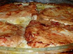 a close up of food in a pan on a stove top with cheese and sauce