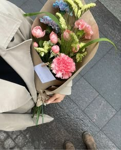 a person holding a bouquet of flowers on the street