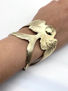 A beautiful Swallow design from the Art Nouveau period. Created from a vintage finding it is made from brass which has been highly polished. It is nickel free and hypoallergenic. It fits a medium sized wrist and has a total circumference is 7 inches. It can be adjusted to fit the size of the person wearing it. Adjustable Antique Gold Engraved Jewelry, Elegant Antique Gold Brass Bracelet, Adjustable Bronze Bracelets For Formal Occasions, Formal Gold Jewelry With Oxidized Finish, Engraved Antique Gold Jewelry, Formal Oxidized Gold Jewelry, Antique Gold Engraved Bracelet, Antique Gold Brass Bracelets For Formal Occasions, Formal Antique Gold Brass Bracelets