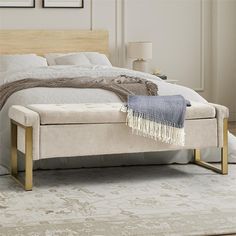 a white bed with a wooden headboard and foot board on top of the bed