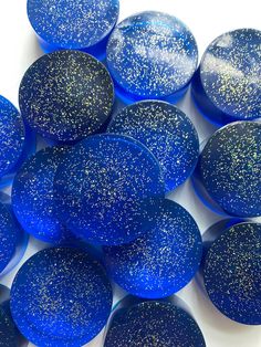 blue and gold speckles are arranged on a white surface, as if they were made out of glass