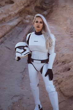 a woman dressed as storm trooper standing in the desert with her hand on her hip