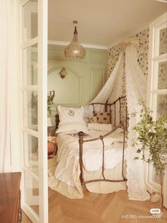 a bed sitting in a bedroom next to an open window with curtains on the top