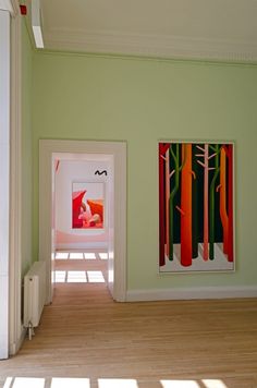 an empty room with two paintings on the wall