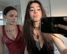 two women are taking a selfie in the mirror