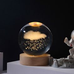 a snow globe sitting on top of a table next to a small white elephant figurine