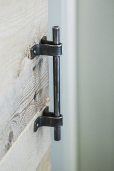 an image of a door handle that is on the side of a wooden door with metal handles