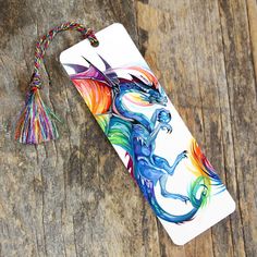 a phone case with a colorful dragon design on the back and tassels attached to it