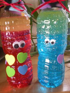 two plastic water bottles with faces painted on them, one blue and the other red