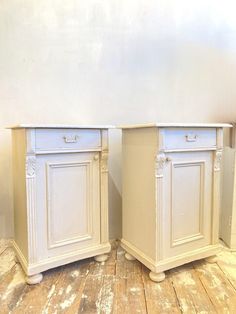 two white cabinets sitting next to each other on top of a wooden floor