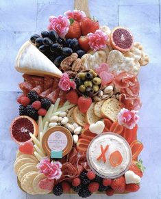 a platter filled with fruit, cheese and crackers