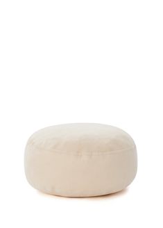 a white round pillow sitting on top of a floor