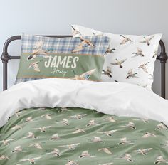 a bed with two pillows and some birds on it